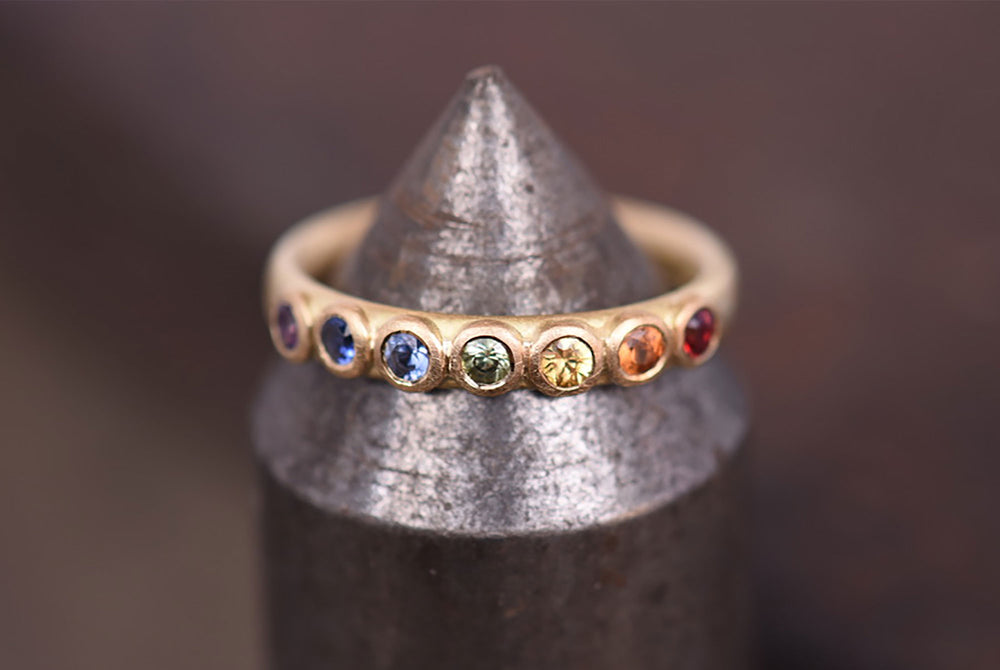 Large rainbow sapphire eternity ring. Made by Goodman Morris.